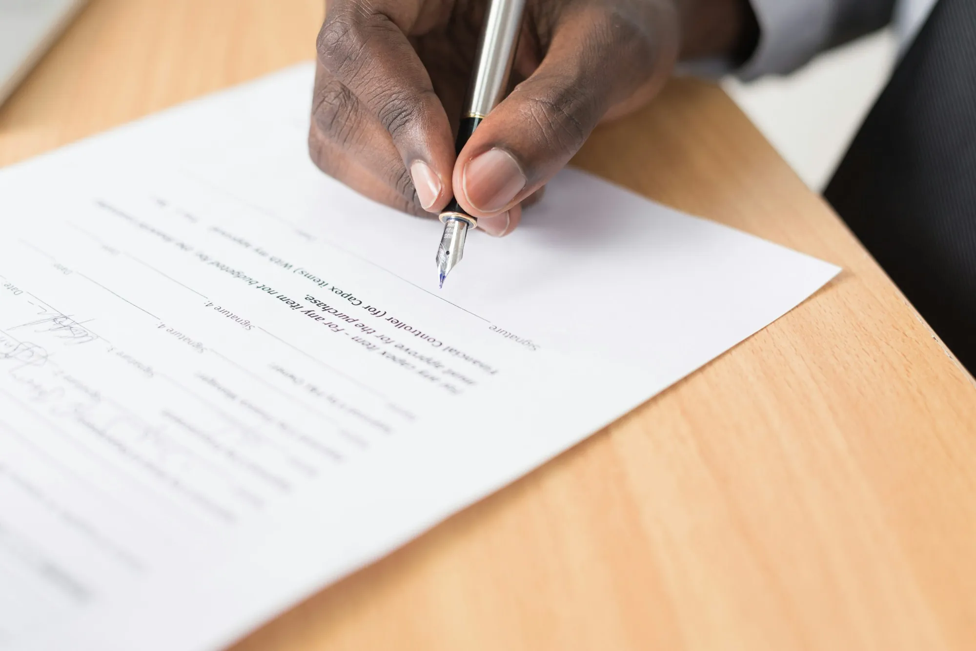 Hand signing a printed agreement with a fountain pen